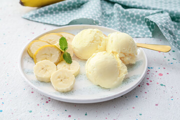Plate with tasty banana ice-cream on light background
