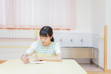 事務作業をする若い幼稚園教諭