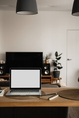 Laptop with blank copy space screen on table with notebooks on wooden table. Minimalist home office workspace. Mockup template.