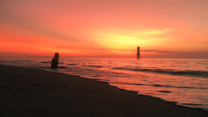 Fototapeta na wymiar A Girl Waiting for very warm sunset in Tropical Island, Lombok. The sister of Bali Indonesia.