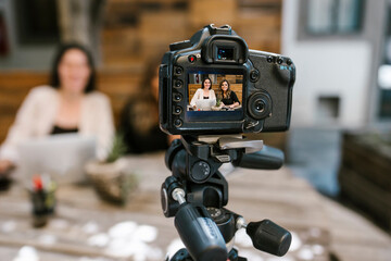 Screen of camera recording a tow Mexican women bloggers talking while making a video in a creative...