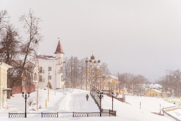 The embankment of the old Russian city of Uglich covered with snow during a heavy snowfall. Winter cityscape.