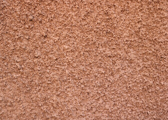 Popcorn ceiling texture of a wall in salmon red or orange color - rough surface background
