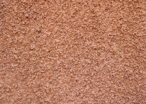 Popcorn ceiling texture of a wall in salmon red or orange color - rough surface background