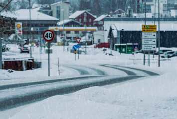 Naklejka premium Road covered in snow and ice leading out of a small city center in Norway.