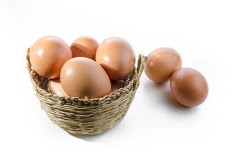 Fresh eggs in and out of a wicker basket on white background. Copy space