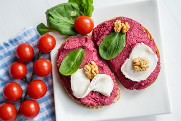 red beetroot brie goat cheese walnut dip sandwich bread spread with salad on white porcelain plate 