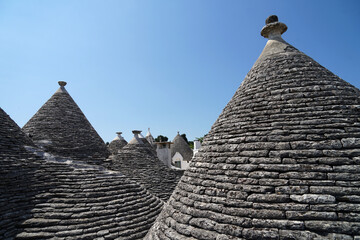 Fototapeta na wymiar Detail of Trullo (Trulli) stone house roofs with hand-worked sandstone pinnacles on top, architecture concept, Alberobello, Apulia, Italy