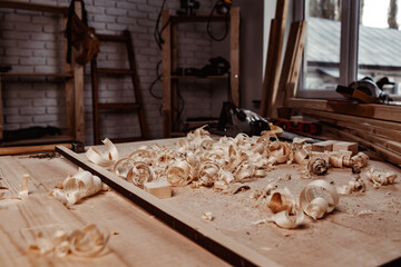 Working table with wood shavings in carpentry workshop
