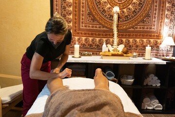 Masseuse giving a leg massage to a client