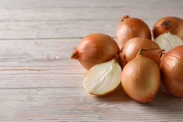 Ripe fresh onion on wooden background, space for text