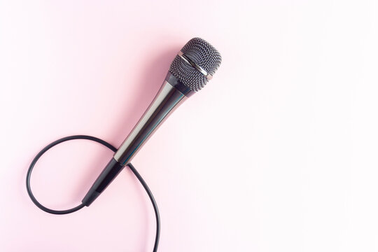Microphone on a colorful pink background close up. Singing, writing music, karaoke online, creativity, vocals concept, symbol. Singing lessons