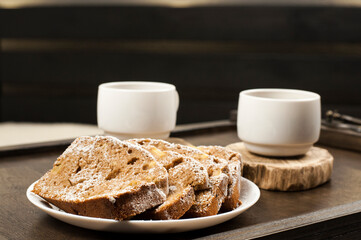 Two white cups of coffee on a wooden table tray. Breakfast in bed