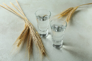Shots of vodka and spikelets on white textured table