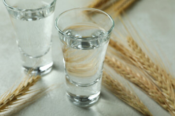Shots of vodka and spikelets on white textured table