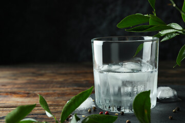 Glass of drink with ice on wooden table