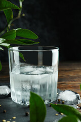 Glass of drink with ice on wooden table