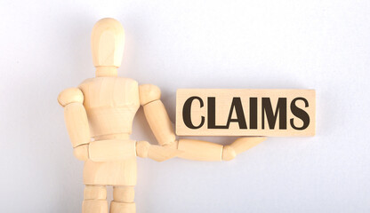Wooden man shows with a hand to block with text CLAIMS
