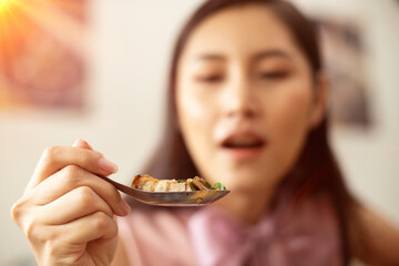 Woman eats Chili Spicy Deep Fried Pork and hanging on spoon