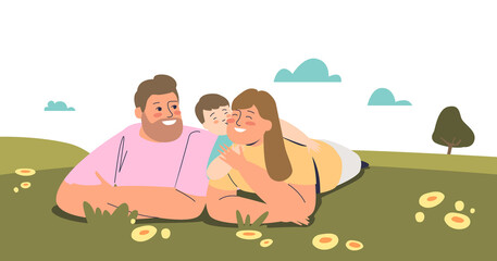 Family couple lying on grass outdoors with little son. Young happy family together