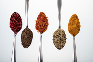Spoons with different spices and seasonings on white background