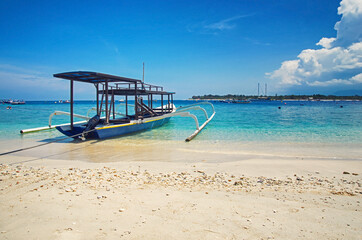 View of wooden fishing boat. Beautiful clear water in the ocean, blue sky in the background.