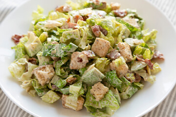 Homemade Bacon Avocado Caesar Salad with Cheese and Croutons, low angle view. Close-up.