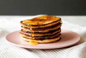 Homemade Peanut Butter Chocolate Pancakes on a pink plate, side view. Close-up.