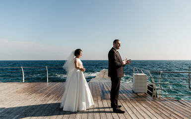 groom with the bride at the sea. meeting of the bride and groom on the pier near the sea. wedding couple. groom with a red beard. the bride goes to the groom