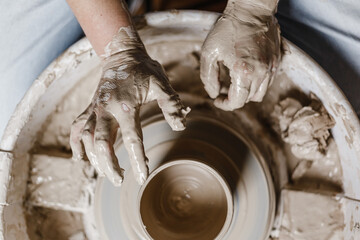 Female hands make dishes from clay