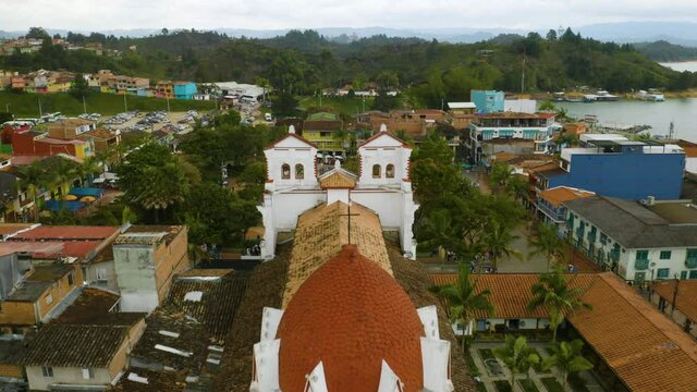 Aerial: Drone Flies Above Church in Guatape, Colombia to Reveal Main Plaza