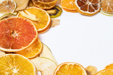 Dried mixed fruits on white background with copy space.  Dried apples, oranges, limes, avocados, pears, kiwi, bananas. Delicious and healthy snack.