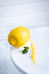 Peel the lemon with a cheese grater. Lemon zest on white background