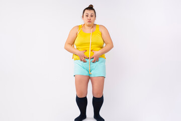 Weight loss, slimming, diet concept. Plus size, XXL woman in home clothing with measuring tape...
