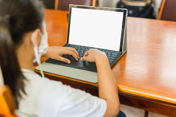 Young student with protective mask hands typing on laptop.