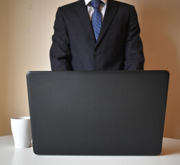 businessman wearing a suit and working with a portatail from home