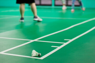 Fototapeta na wymiar White badminton shuttlecock on a green floor. badminton courts with players competing.