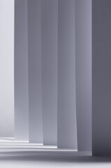 Abstract white grey background with contrast perspective of stripes, light and shadow as pattern, vertical.