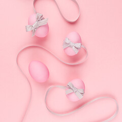 Simplicity purity easter background - pink eggs with curved grey ribbons on pastel pink, square.