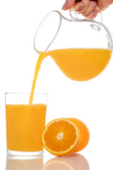 Orange juice pouring from pitcher into glass, isolated on white background