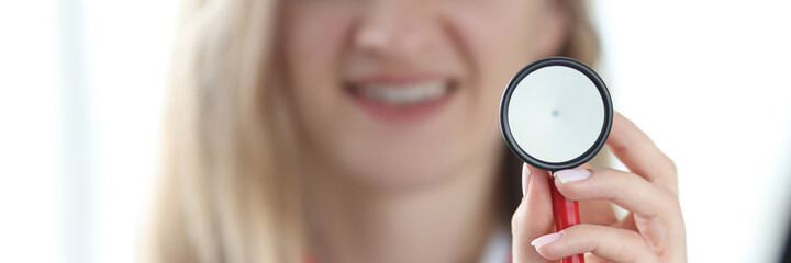 Woman doctor therapist holding stethoscope in her hands closeup