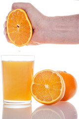 Hand squeezed fresh orange juice into a glass isolated on white background