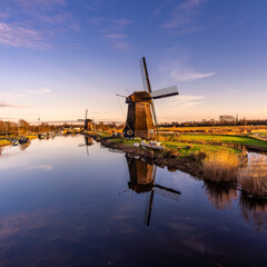 Two Ancient Windmills by the River at sunset