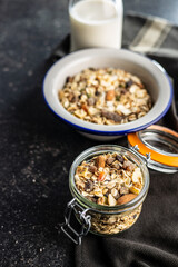 Beakfast cereals in jar. Healthy muesli with oat flakes, nuts and raisins