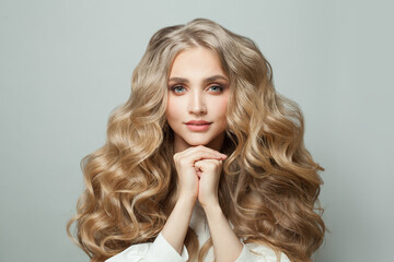 Stylish blonde woman with healthy hair on white background