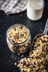 Beakfast cereals in jar. Healthy muesli with oat flakes, nuts and raisins