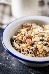 Beakfast cereals in bowl. Healthy muesli with oat flakes, nuts and raisins