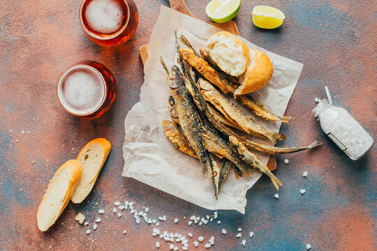 top view of fried fish, beer, baguette