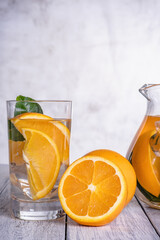 Healthy orange detox with fresh orange and lime, in glass.