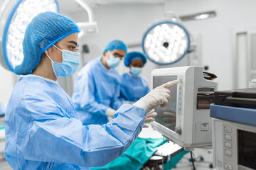 Anesthesiologist keeping track of vital functions of the body during cardiac surgery. Surgeon...